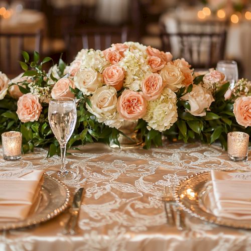 A beautifully decorated table with floral centerpieces, elegant place settings, and candles, perfect for a formal event or wedding reception.