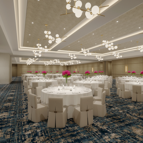The image shows an elegant banquet hall with round tables, white chairs, chandeliers, and floral centerpieces.