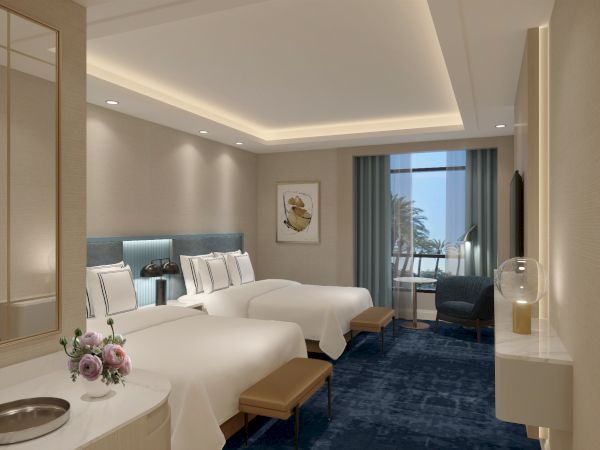 The image shows a hotel room with two beds, a modern design, blue carpet, and a window view. There's a table, TV, and decor items.