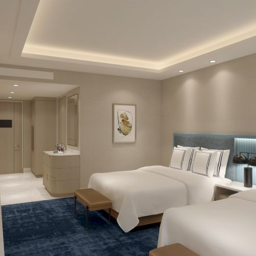 The image shows a modern hotel room with two beds, a blue rug, recessed lighting, and a small hallway leading to a bathroom area.