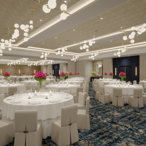 A large, elegant banquet hall with round tables, white chairs, pink floral centerpieces, modern lighting, and a patterned carpet.