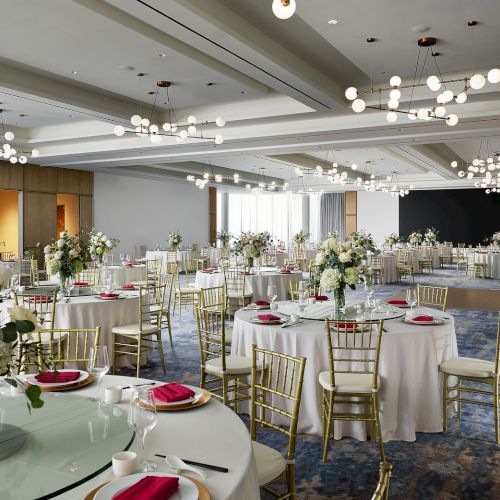 Ballroom at Hilton Arcadia Pasadena Area set for a banquet reception with round tables and floral centerpieces