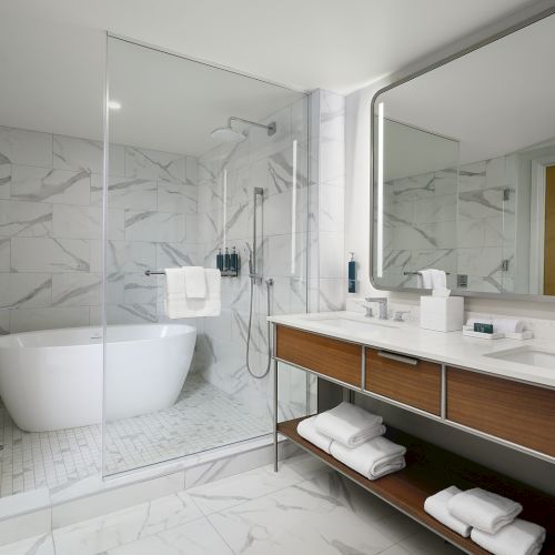 Marble suite bathroom at Hilton Arcadia Pasadena Area with a freestanding soaking tub and glass walk-in shower