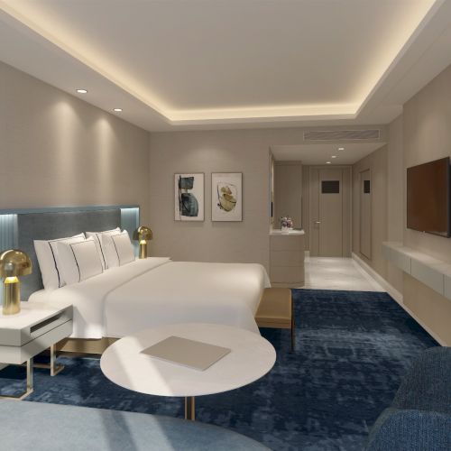 The image shows a modern hotel room with a large bed, blue carpet, wall art, a TV, and soft lighting creating a warm and inviting atmosphere.