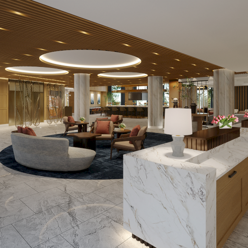 This image shows a modern hotel lobby with elegant marble counters, stylish seating, warm lighting, and decorative plants.