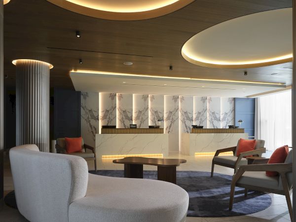 Lobby and front desk at Hilton Arcadia Pasadena Area with marble counters and lounge seating
