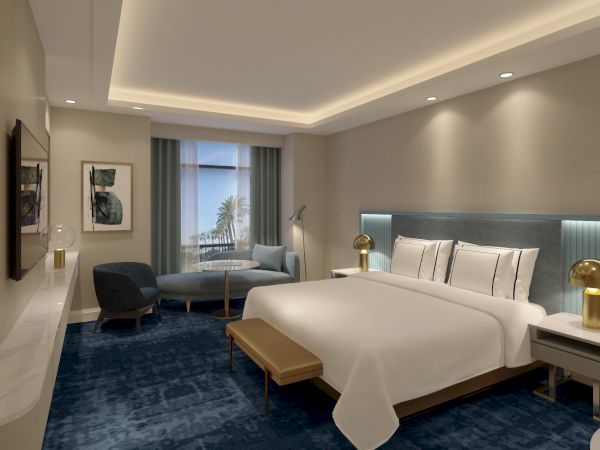 A modern hotel room with a large bed, nightstands with lamps, a lounge chair, and a window with curtains.