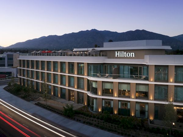 Hilton Arcadia Pasadena Area exterior at dusk with the San Gabriel Mountains behind