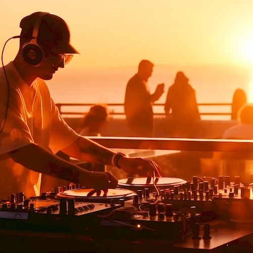 A DJ wearing headphones tunes turntables at sunset on a beach club, with silhouettes dancing and a warm orange glow. Ends with a period.